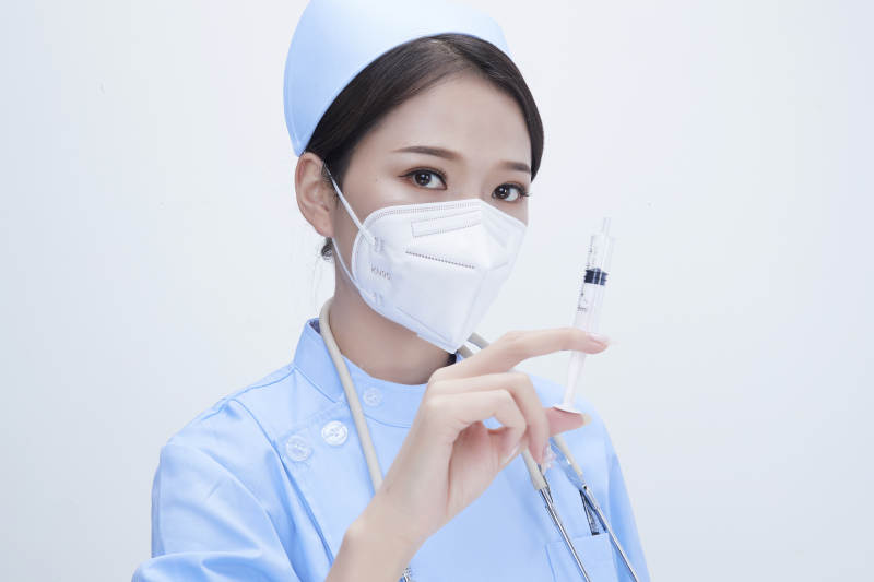 穿护士服戴听诊器口罩和手执针筒的美女护士图片