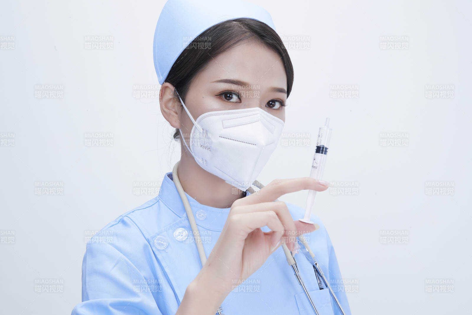 穿护士服戴听诊器口罩和手执针筒的美女护士图片