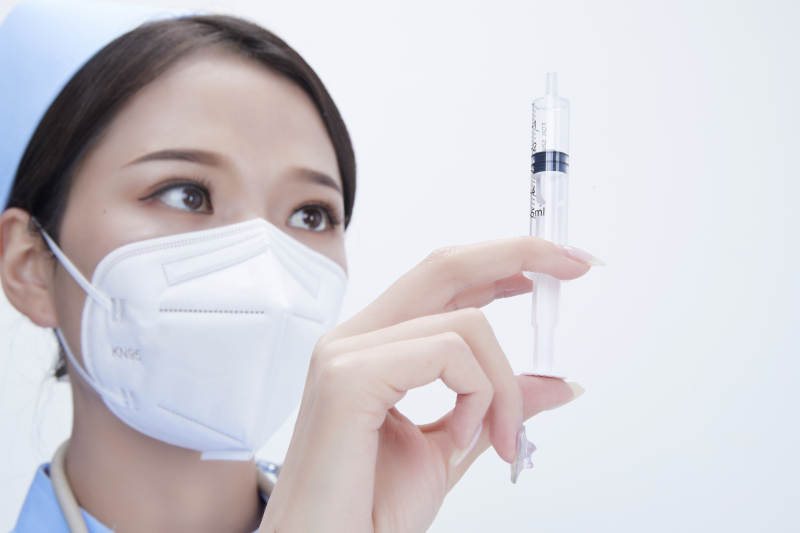 穿护士服戴听诊器口罩和手执针筒的美女护士图片