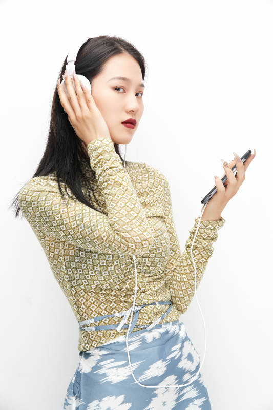 头戴耳机手持电话听音乐的少女图片