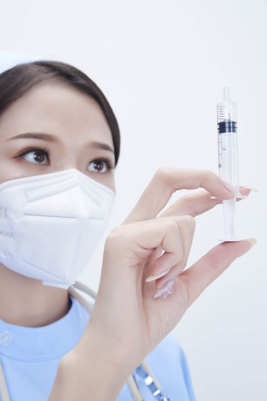 穿护士服戴听诊器口罩和手执针筒的美女护士图片