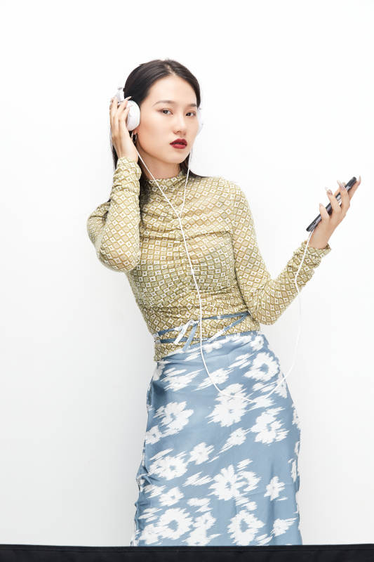 头戴耳机手持电话听音乐的少女图片