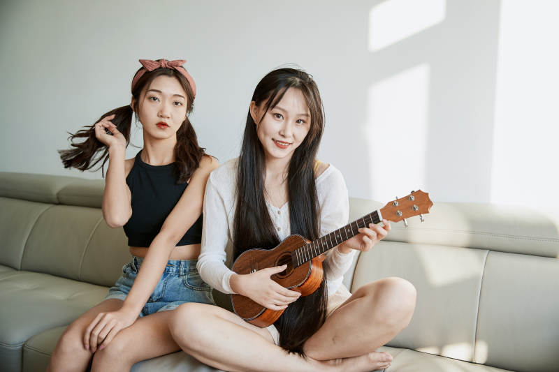 坐在沙发弹琴唱歌俩位美女闺蜜图片