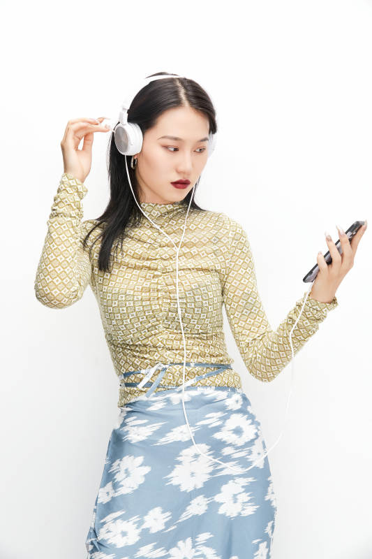 头戴耳机手持电话听音乐的少女图片