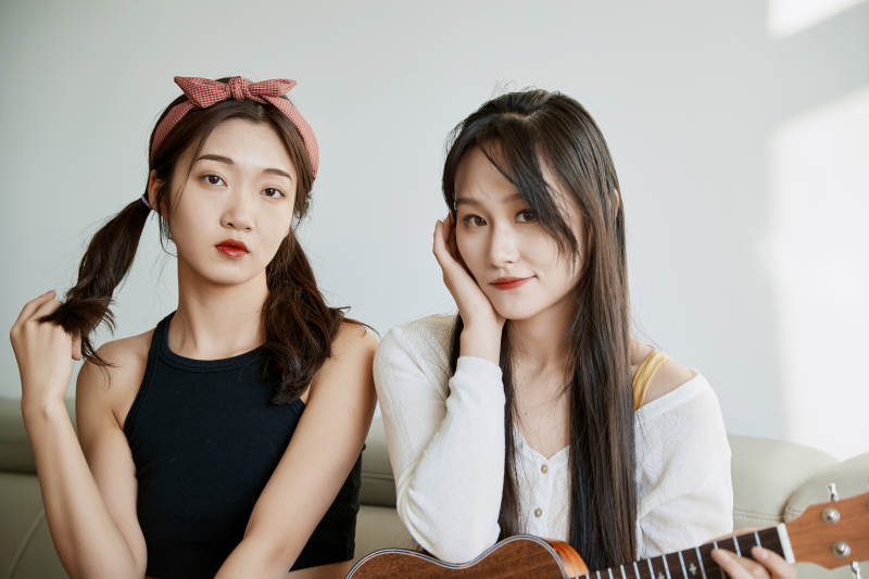 坐在沙发弹琴唱歌俩位美女闺蜜图片