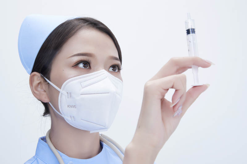 穿护士服戴听诊器口罩和手执针筒的美女护士图片