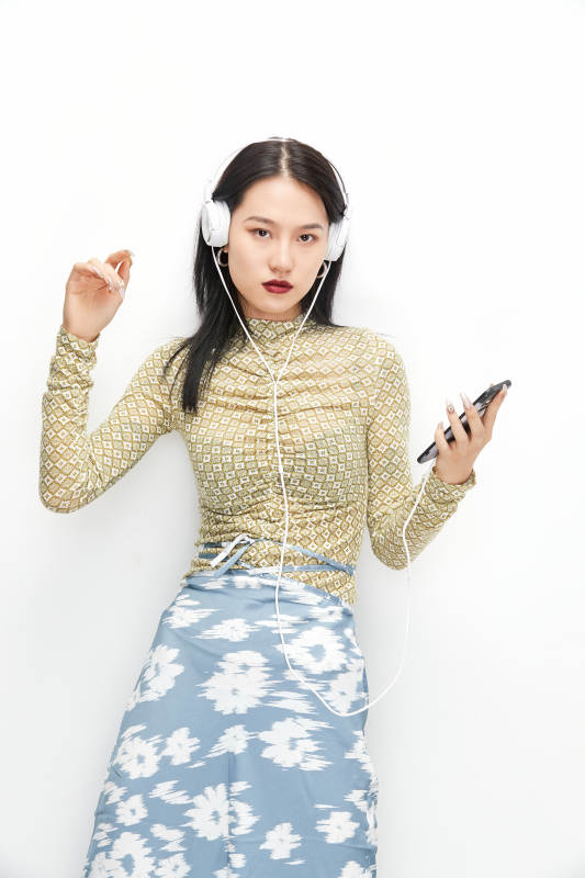 头戴耳机手持电话听音乐的少女图片