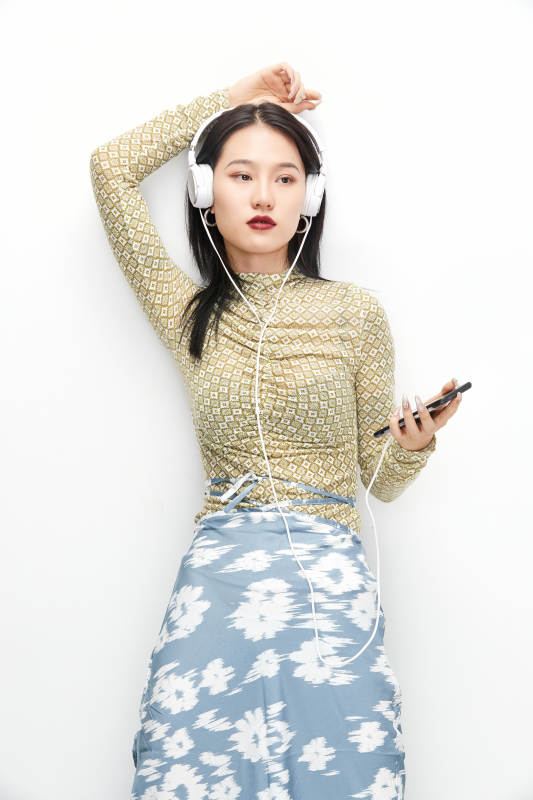 头戴耳机手持电话听音乐的少女图片