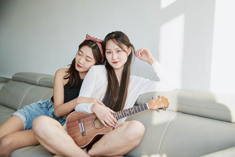 坐在沙发弹琴唱歌俩位美女闺蜜图片