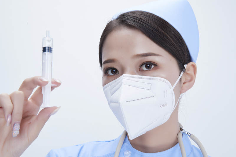 穿护士服戴听诊器口罩和手执针筒的美女护士图片