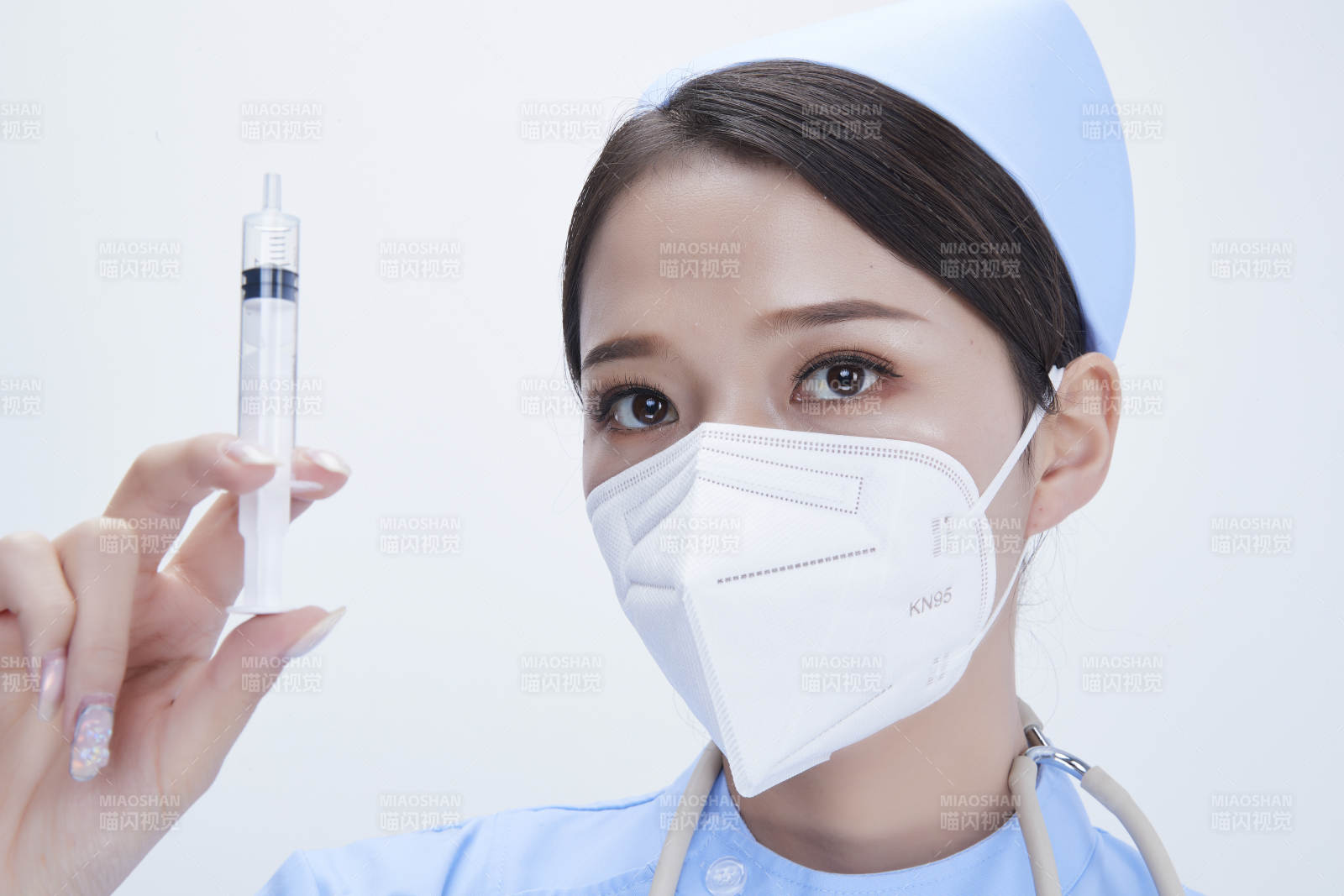 穿护士服戴听诊器口罩和手执针筒的美女护士图片