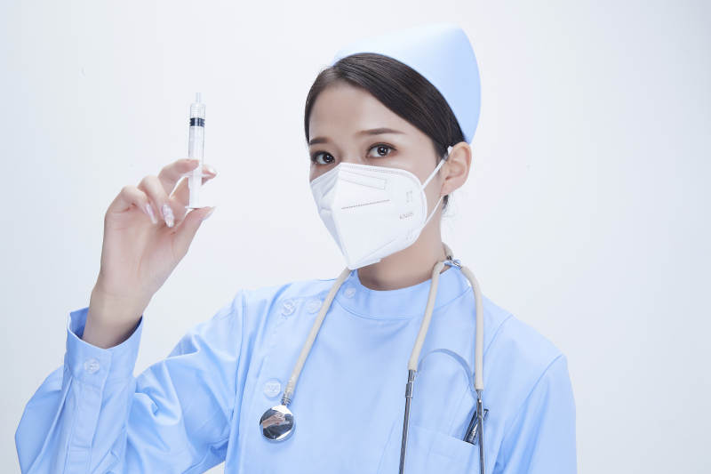 穿护士服戴听诊器口罩和手执针筒的美女护士图片