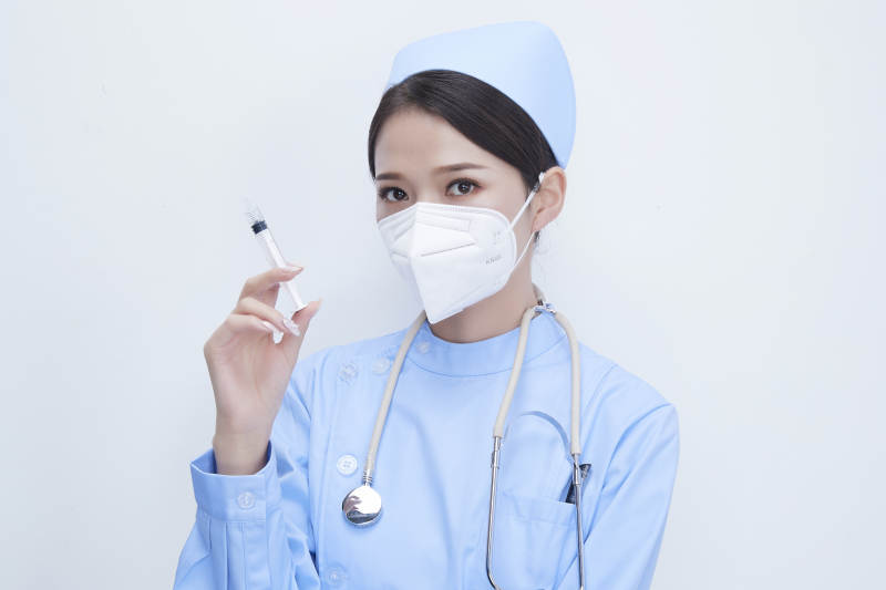 穿护士服戴听诊器口罩和手执针筒的美女护士图片