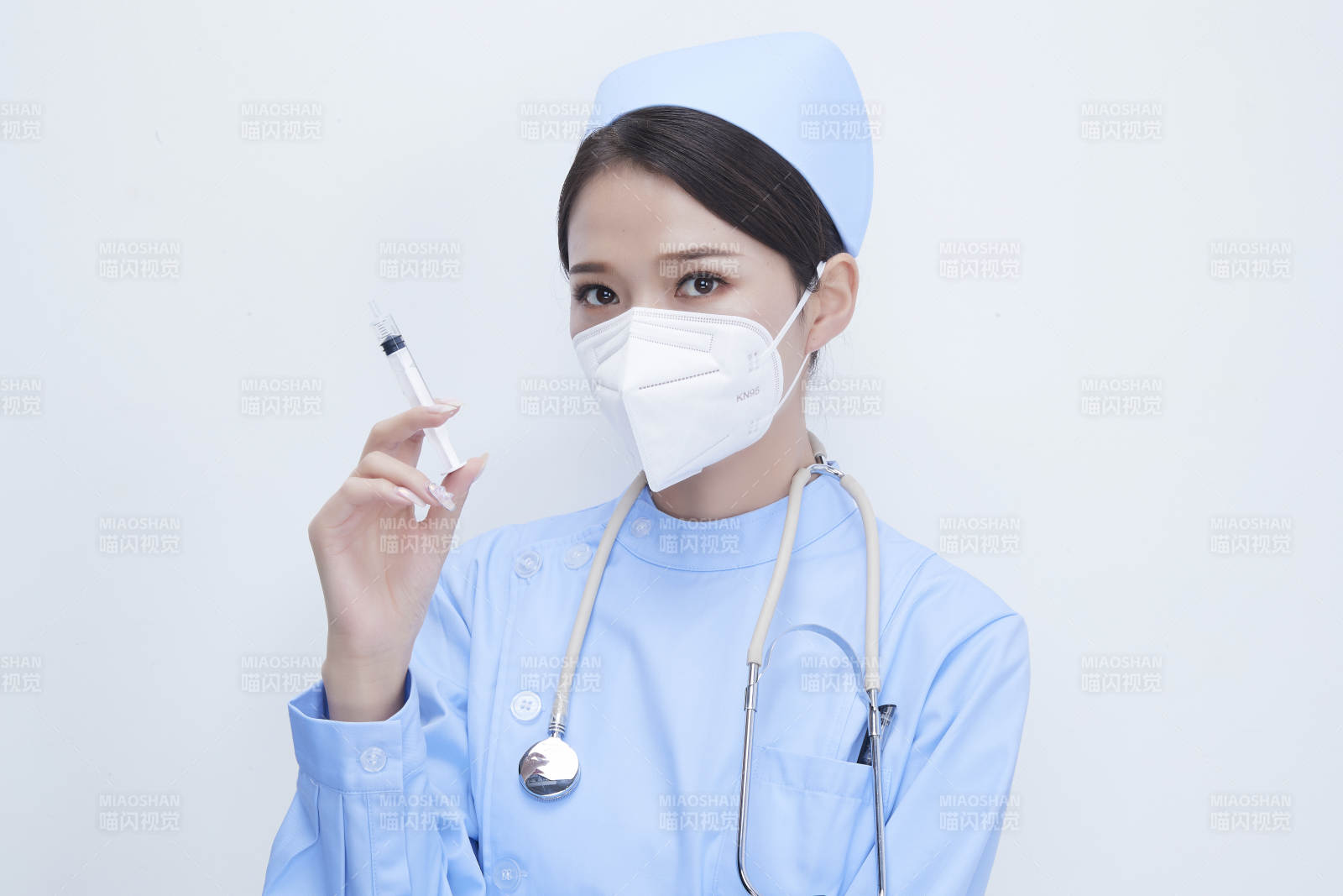 穿护士服戴听诊器口罩和手执针筒的美女护士图片