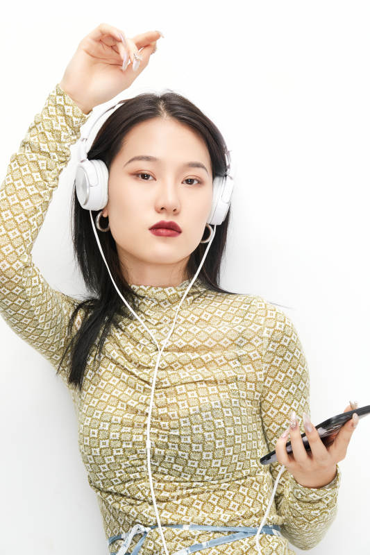 头戴耳机手持电话听音乐的少女图片