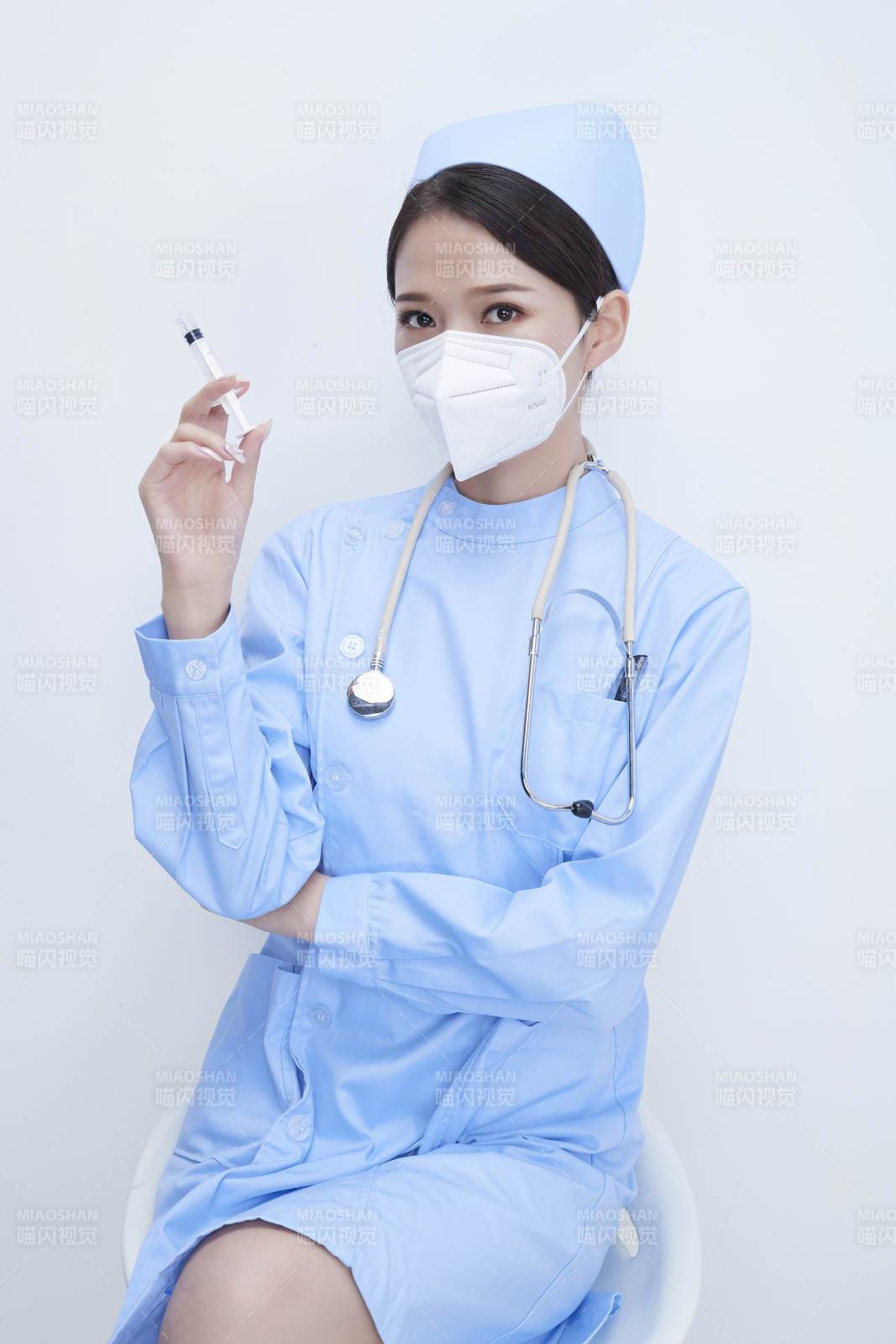 穿护士服戴听诊器口罩和手执针筒的美女护士图片