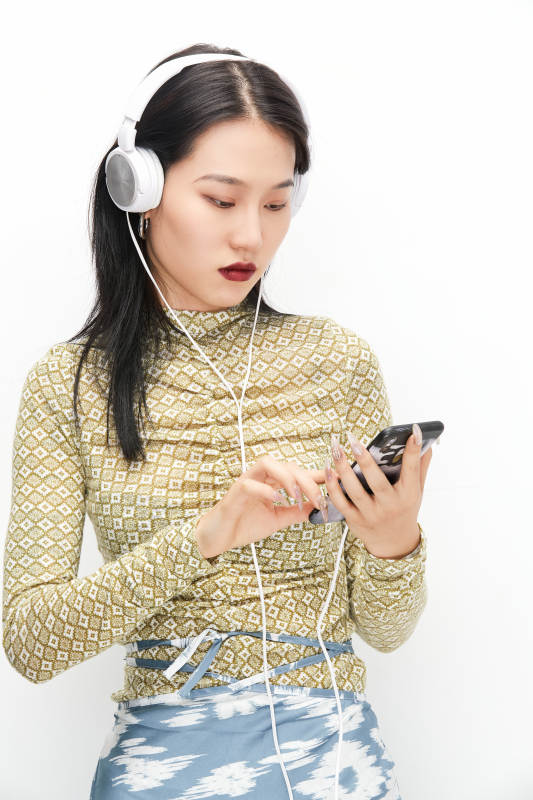 头戴耳机手持电话听音乐的少女图片