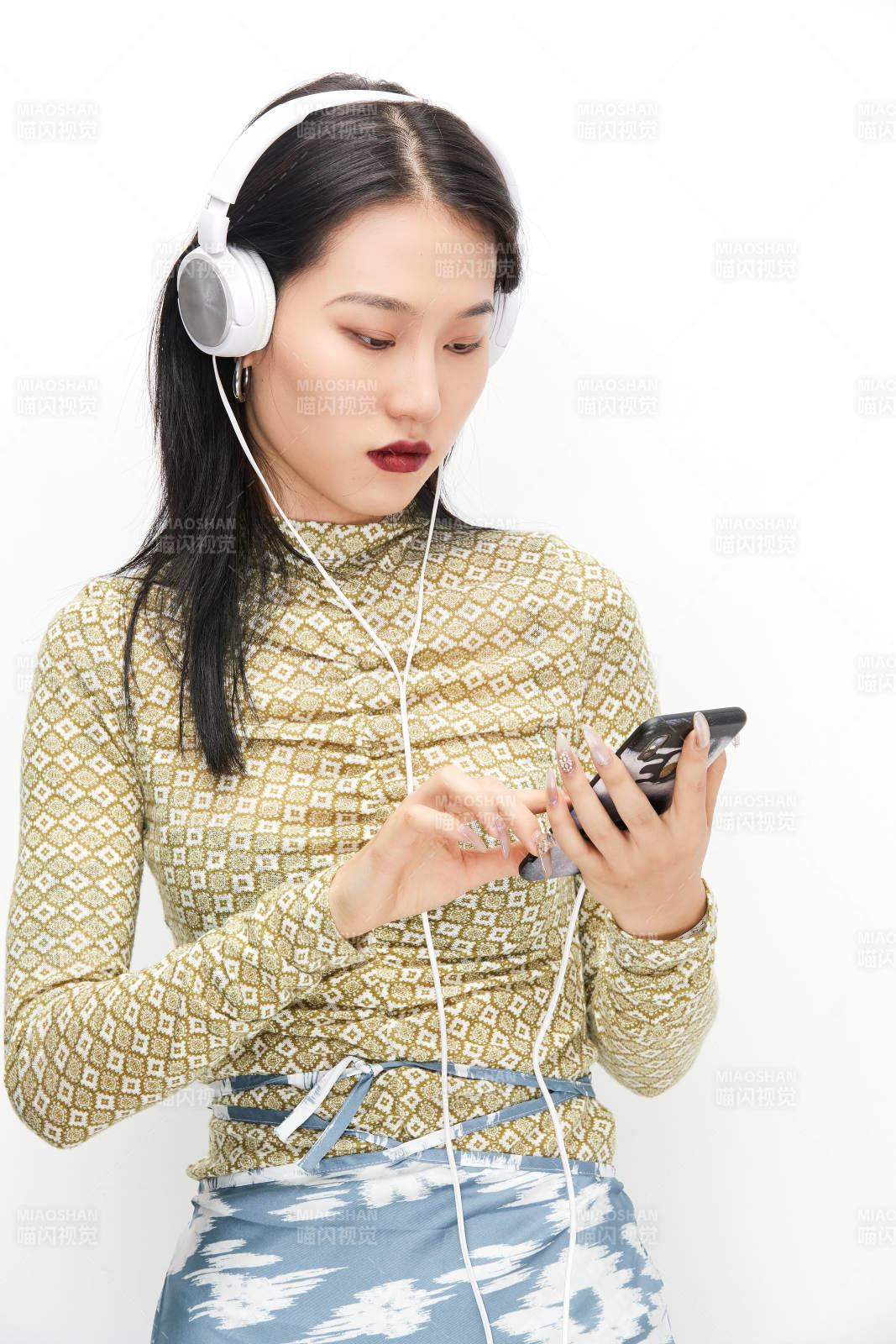 头戴耳机手持电话听音乐的少女图片