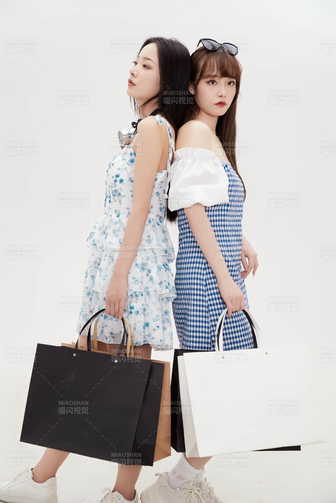 白色背景下手提购物袋时尚美丽的美女闺蜜图片