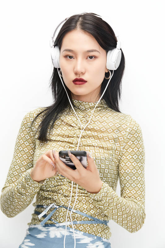 头戴耳机手持电话听音乐的少女图片