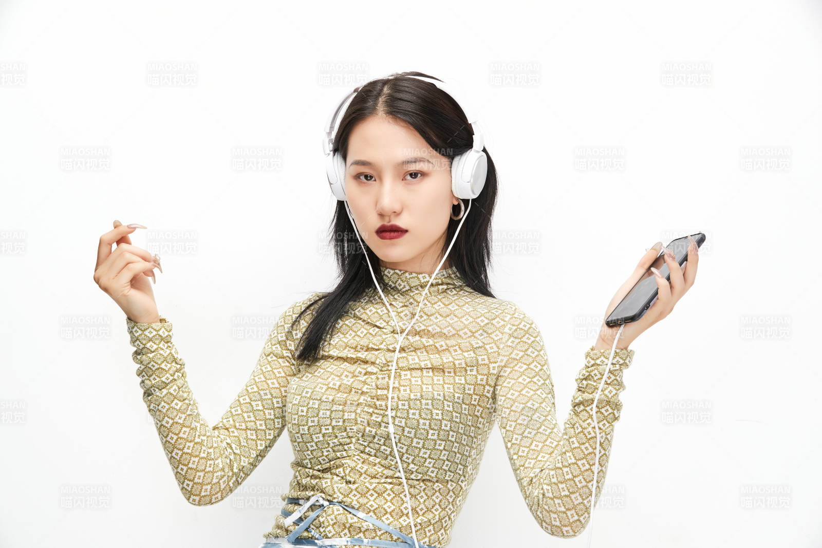 头戴耳机手持电话听音乐的少女图片