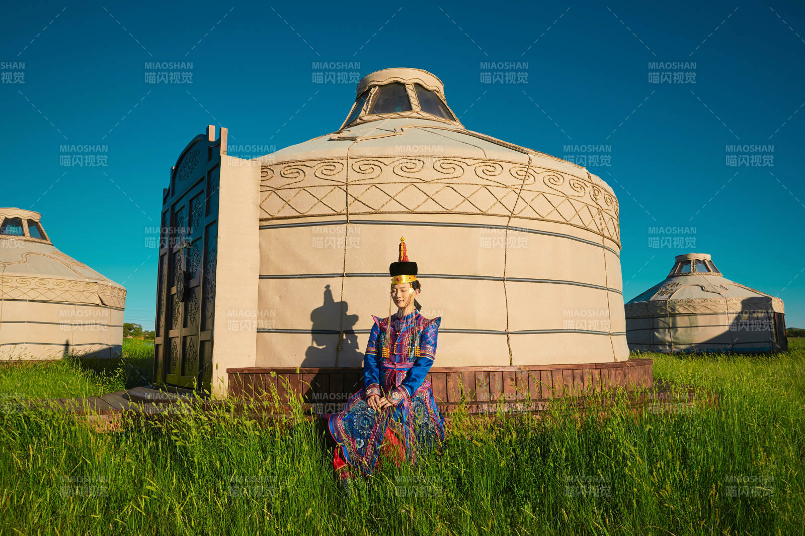 夕阳下草原蒙古大帐前穿蒙族服饰的美女图片