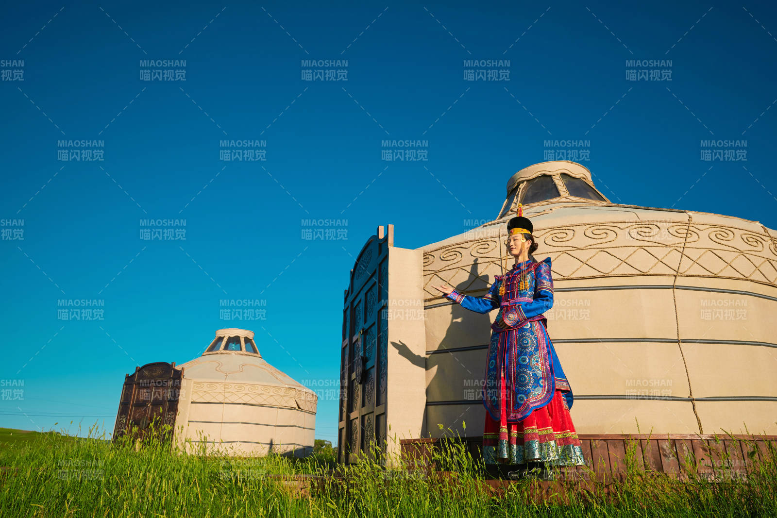 夕阳下草原蒙古大帐前穿蒙族服饰的美女图片