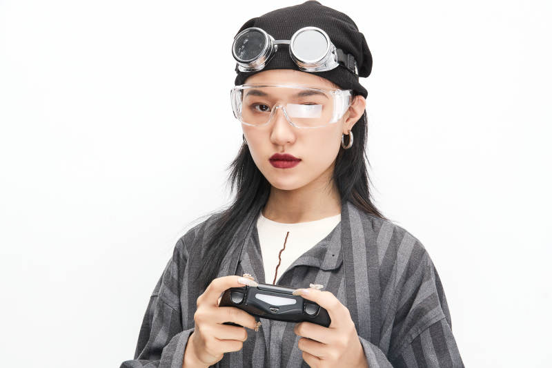 手持电子游戏操控器的亚洲少女图片