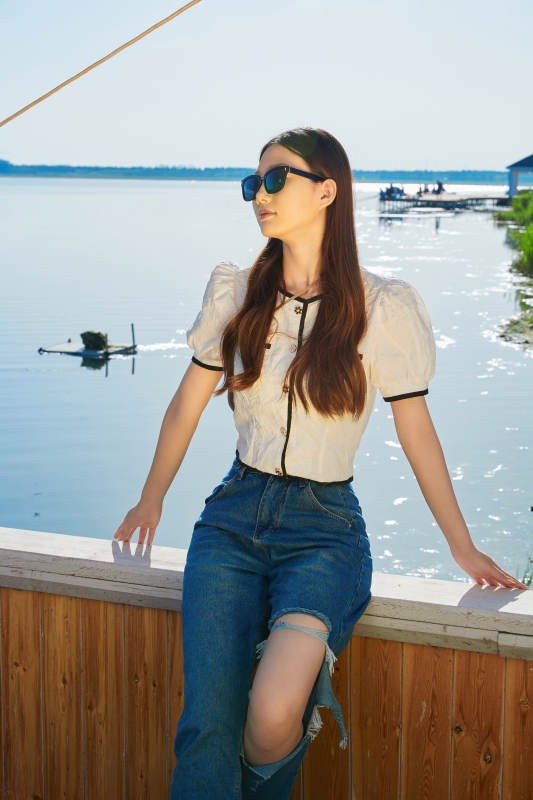 在湖畔木制帆船上的亚洲美女图片