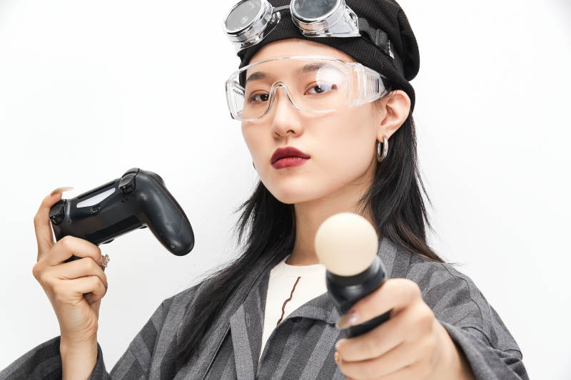 手持电子游戏操控器的亚洲少女图片