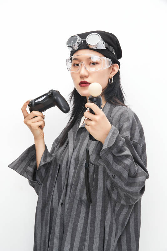 手持电子游戏操控器的亚洲少女图片