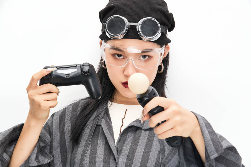 手持电子游戏操控器的亚洲少女图片