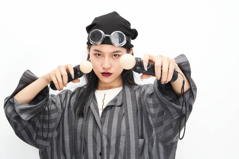 手持电子游戏操控器的亚洲少女图片