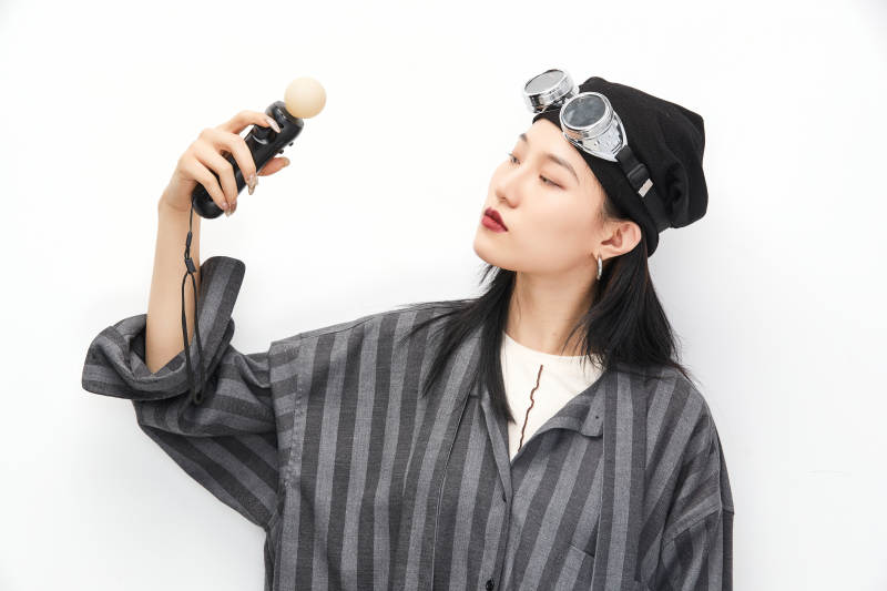 手持电子游戏操控器的亚洲少女图片