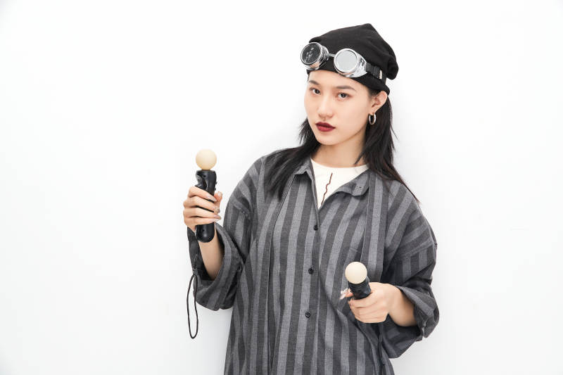 手持电子游戏操控器的亚洲少女图片