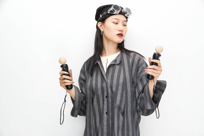 手持电子游戏操控器的亚洲少女图片