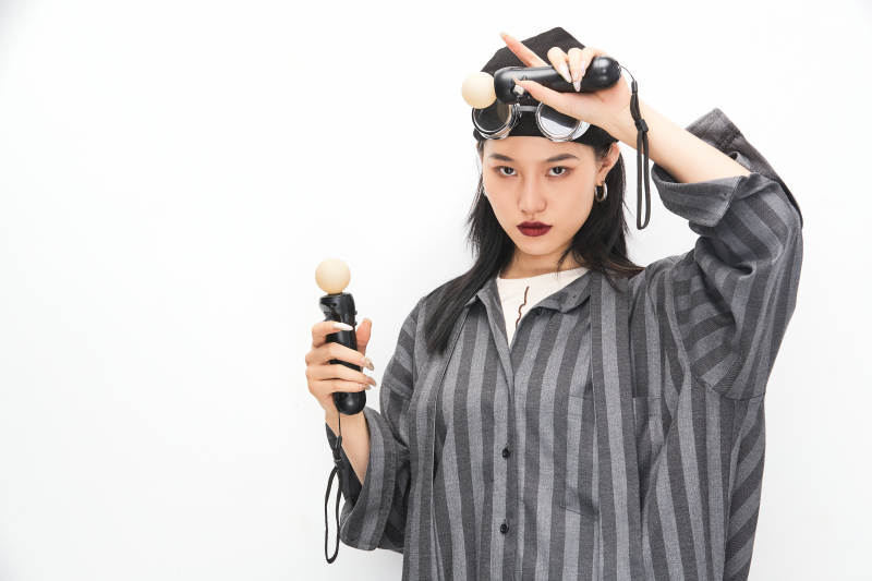 手持电子游戏操控器的亚洲少女图片