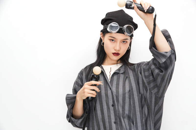 手持电子游戏操控器的亚洲少女图片