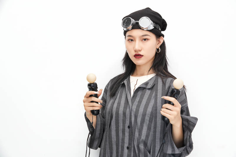 手持电子游戏操控器的亚洲少女图片