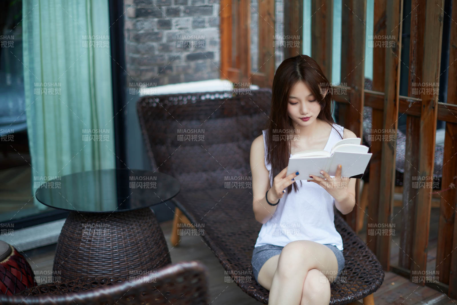 院子里坐在长椅上阅读书籍的亚洲长发少女图片