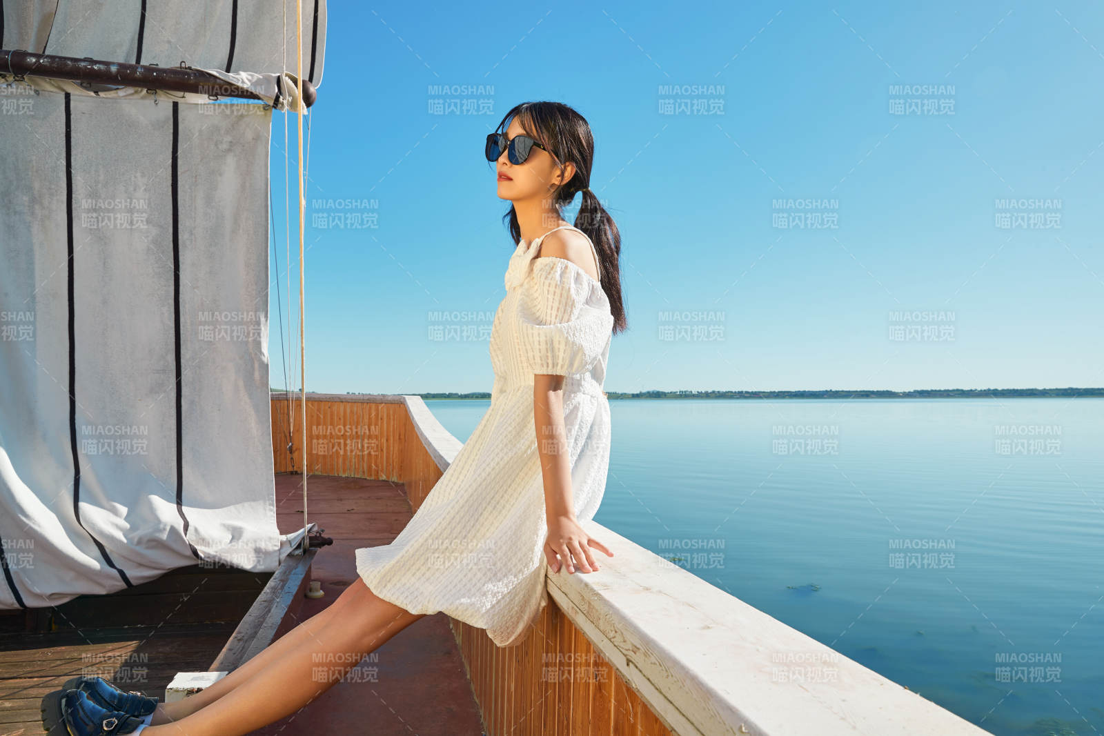 在湖畔木制帆船上的亚洲美女图片