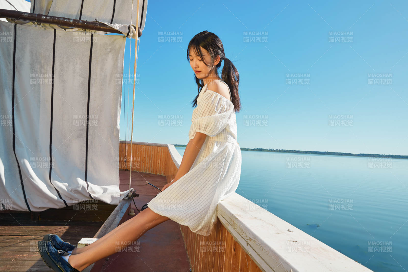 在湖畔木制帆船上的亚洲美女图片