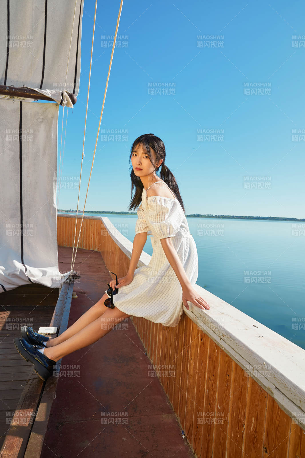 在湖畔木制帆船上的亚洲美女图片