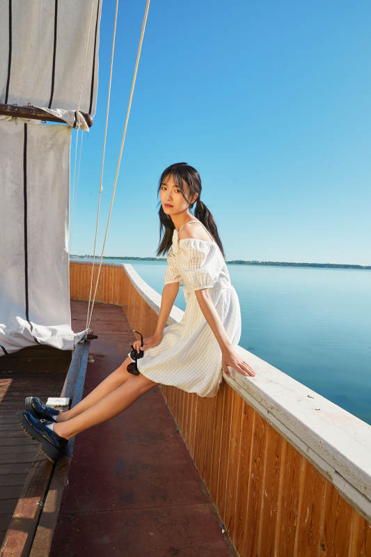 在湖畔木制帆船上的亚洲美女图片