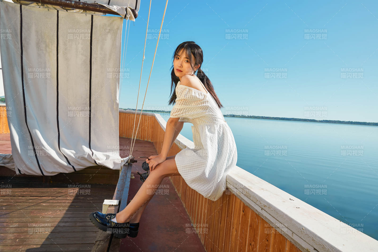 在湖畔木制帆船上的亚洲美女图片