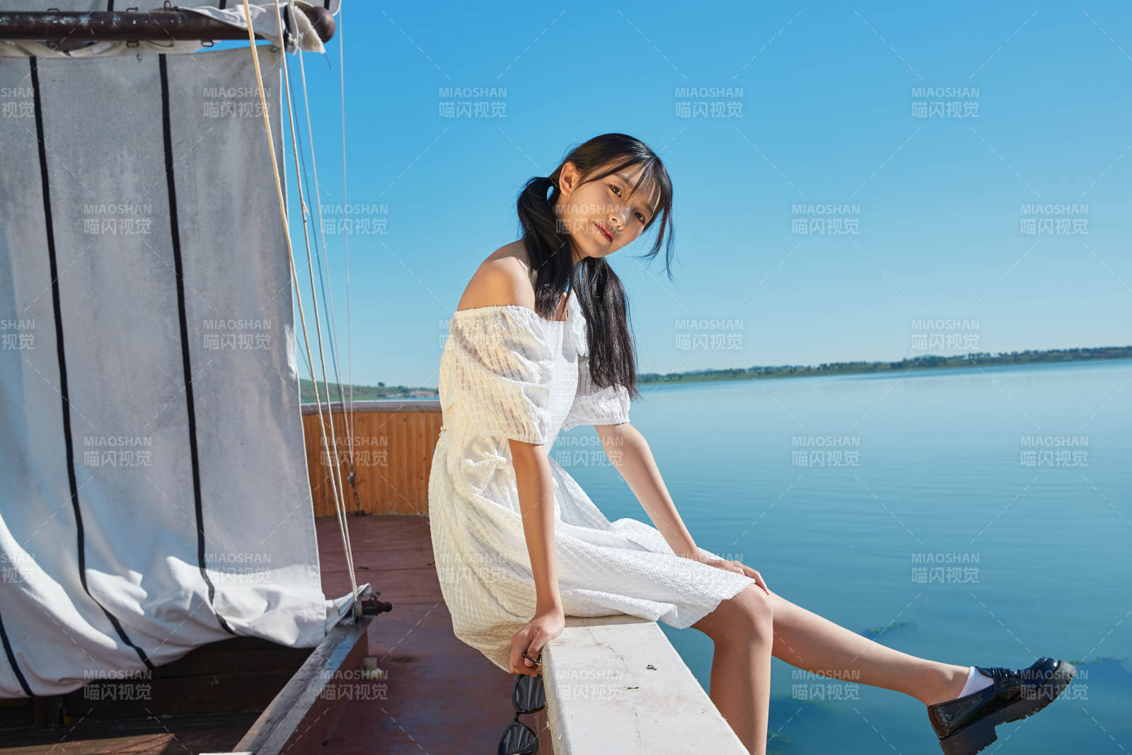 在湖畔木制帆船上的亚洲美女图片