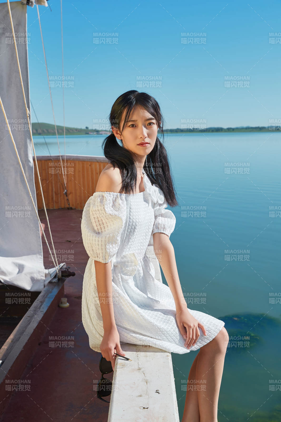 在湖畔木制帆船上的亚洲美女图片