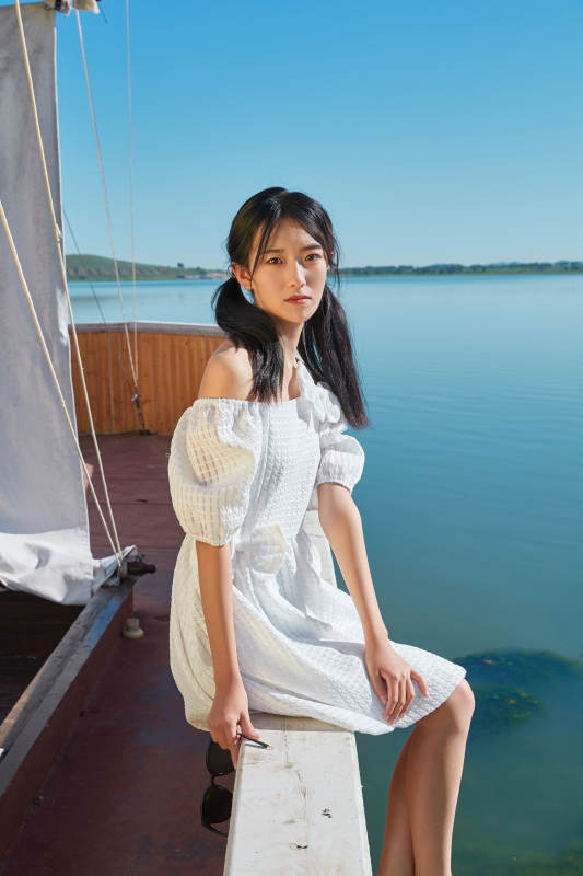 在湖畔木制帆船上的亚洲美女图片