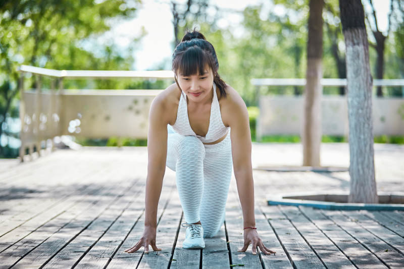 湖畔公园做瑜伽动作的亚洲年轻女性图片