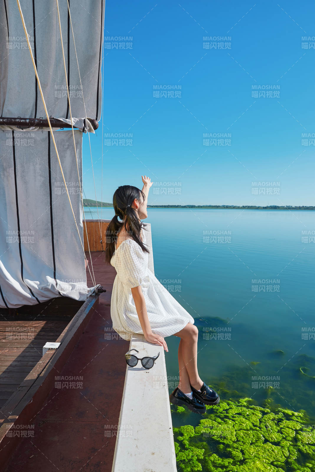 在湖畔木制帆船上的亚洲美女图片